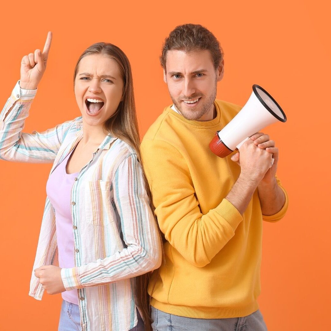 kaks noort, ühel käes ruupor, üks näitab käega ülespoole