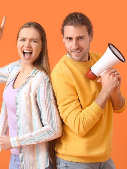 kaks noort, ühel käes ruupor, üks näitab käega ülespoole