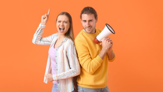 kaks noort, ühel käes ruupor, üks näitab käega ülespoole